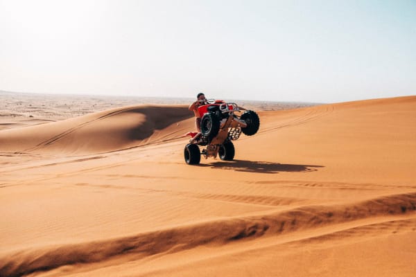 Quad bike wheelie on sand dunes