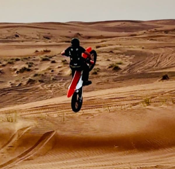 Motorbike jump over sand dunes