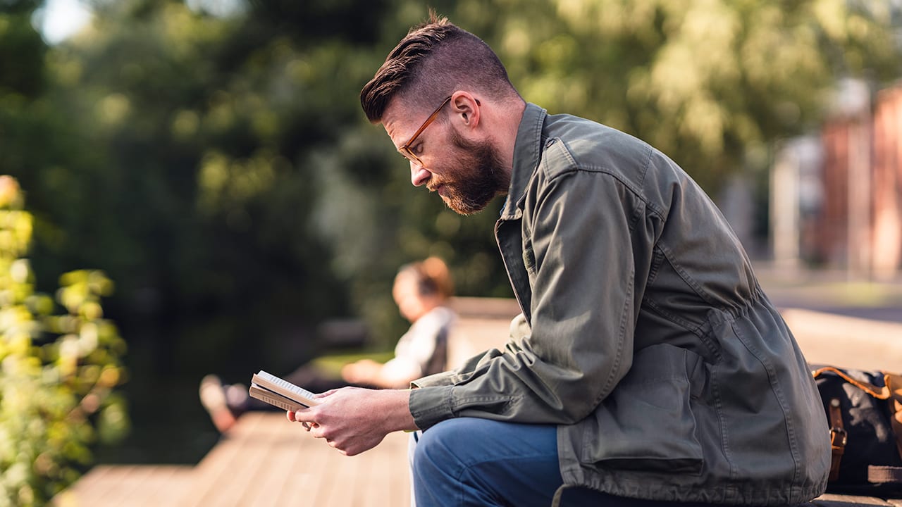 man reading outside in the sun