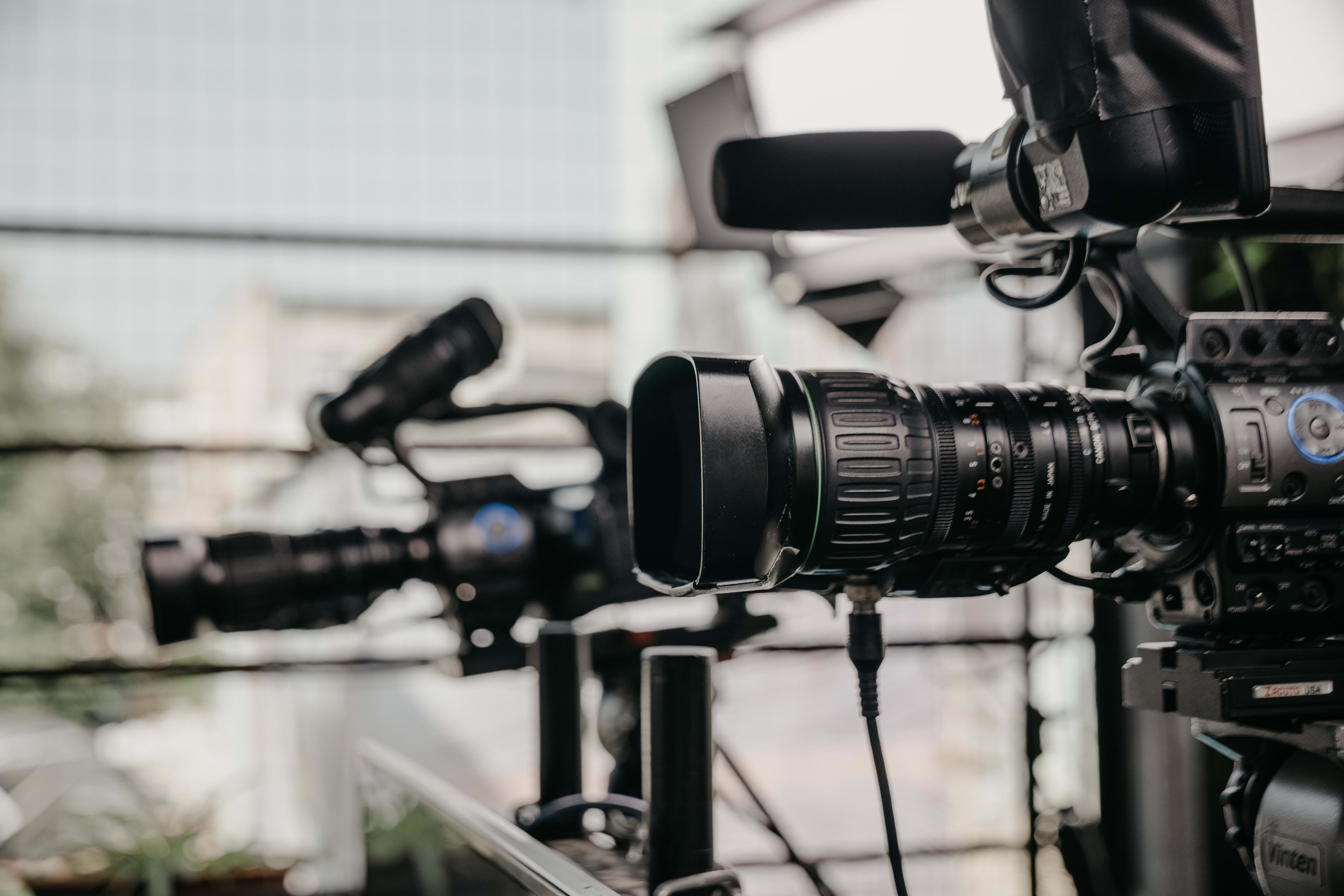 2 large black film cameras with mics ready to record the event