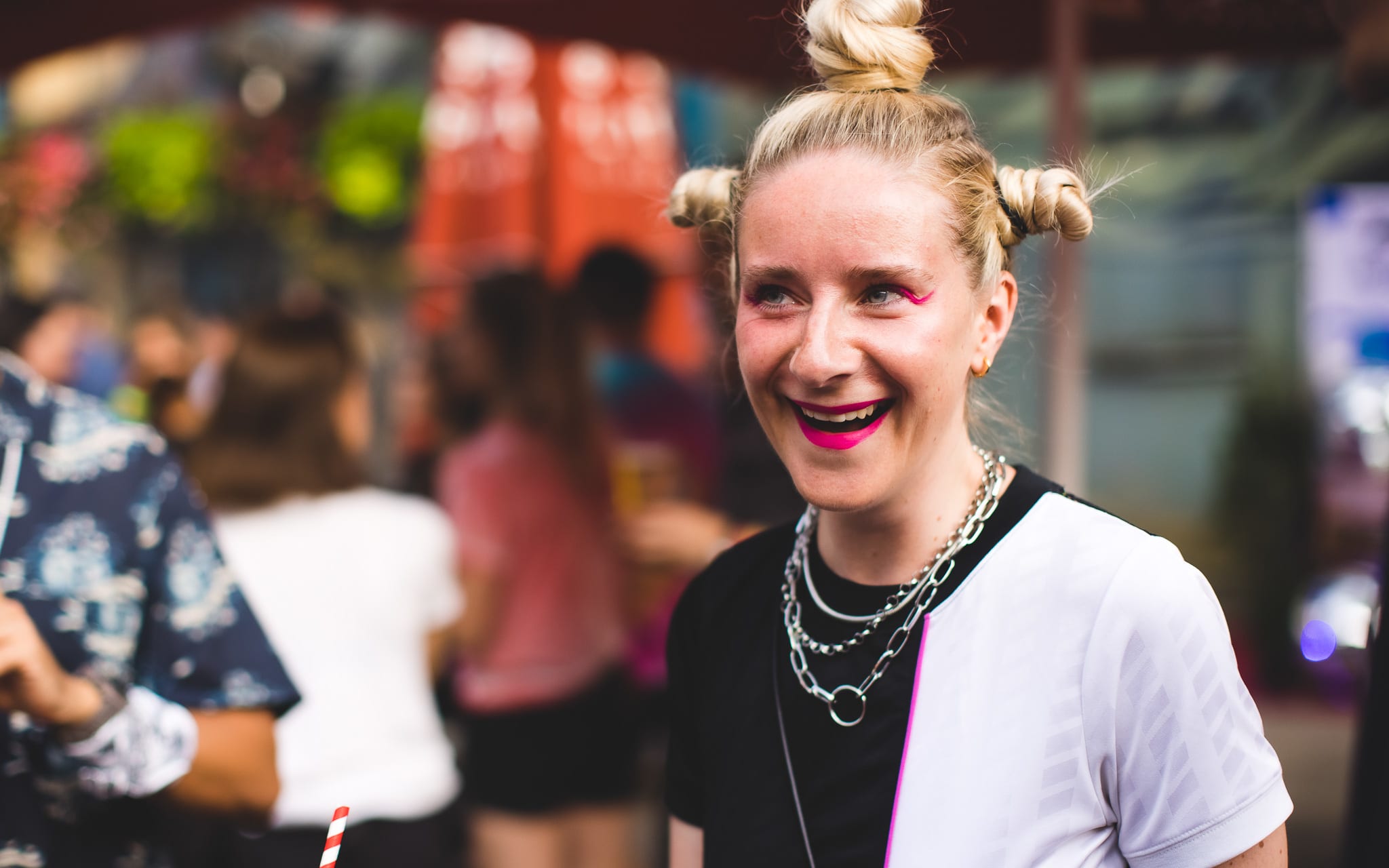 a smiling blonde woman with pigtails and silver chains around her neck enjoying the party