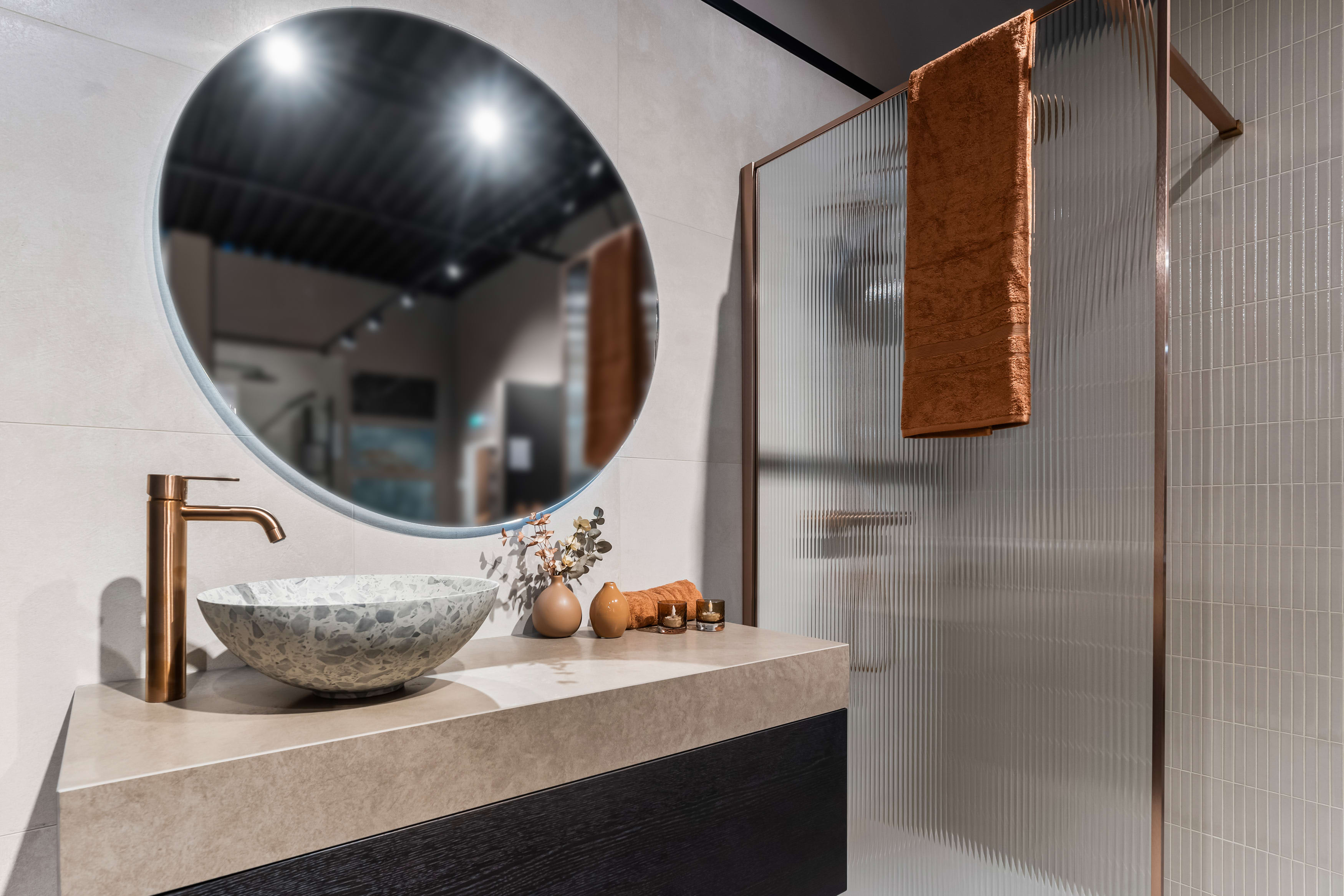 Baderom med fliser, terrazzo bolleservant, servantbatteri i kobber og dusjvegg med rillet glass fra Korsbakken