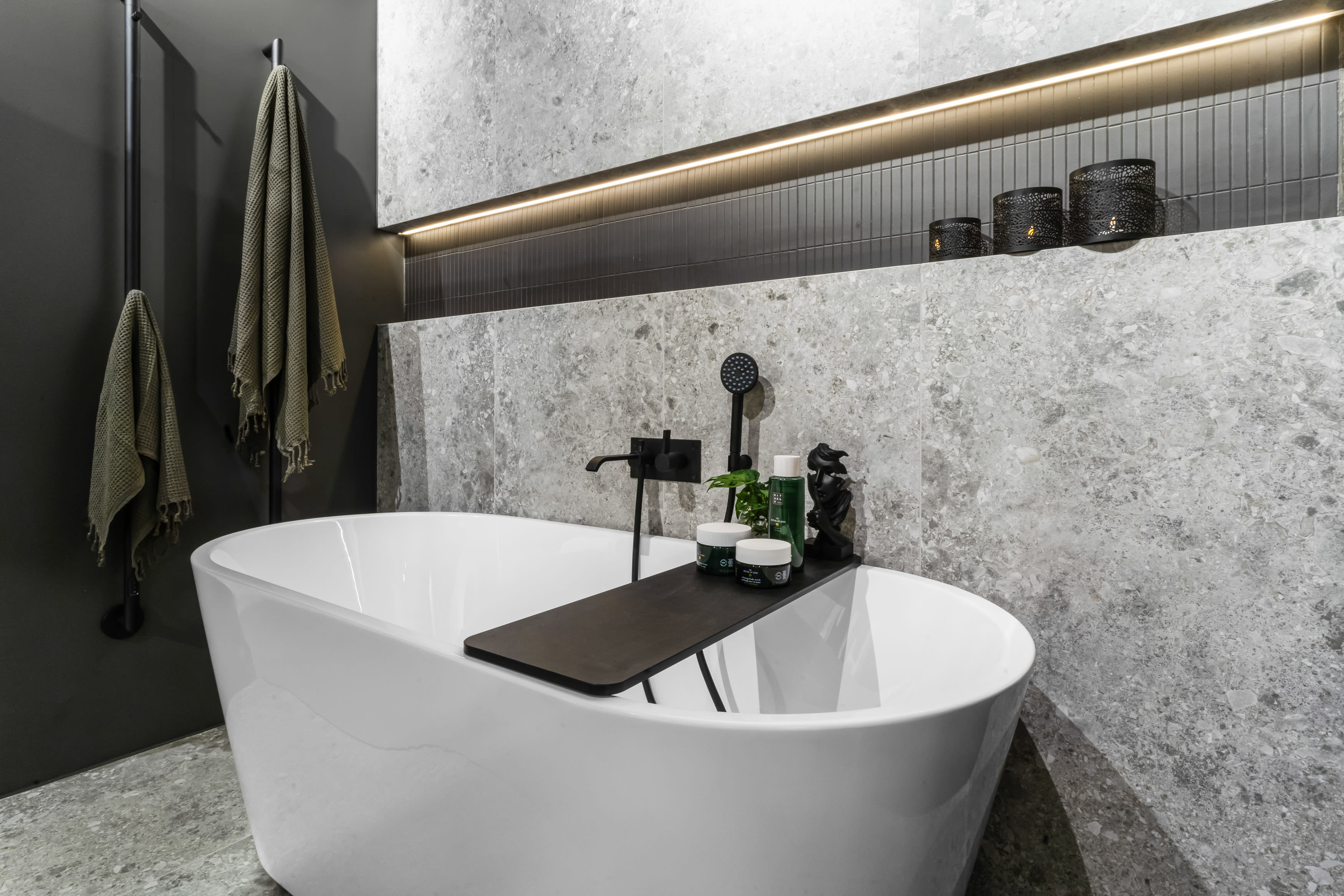 Baderom med ceppo fliser som gulvfliser og veggfliser. Frittstående badekar med matt sort armatur