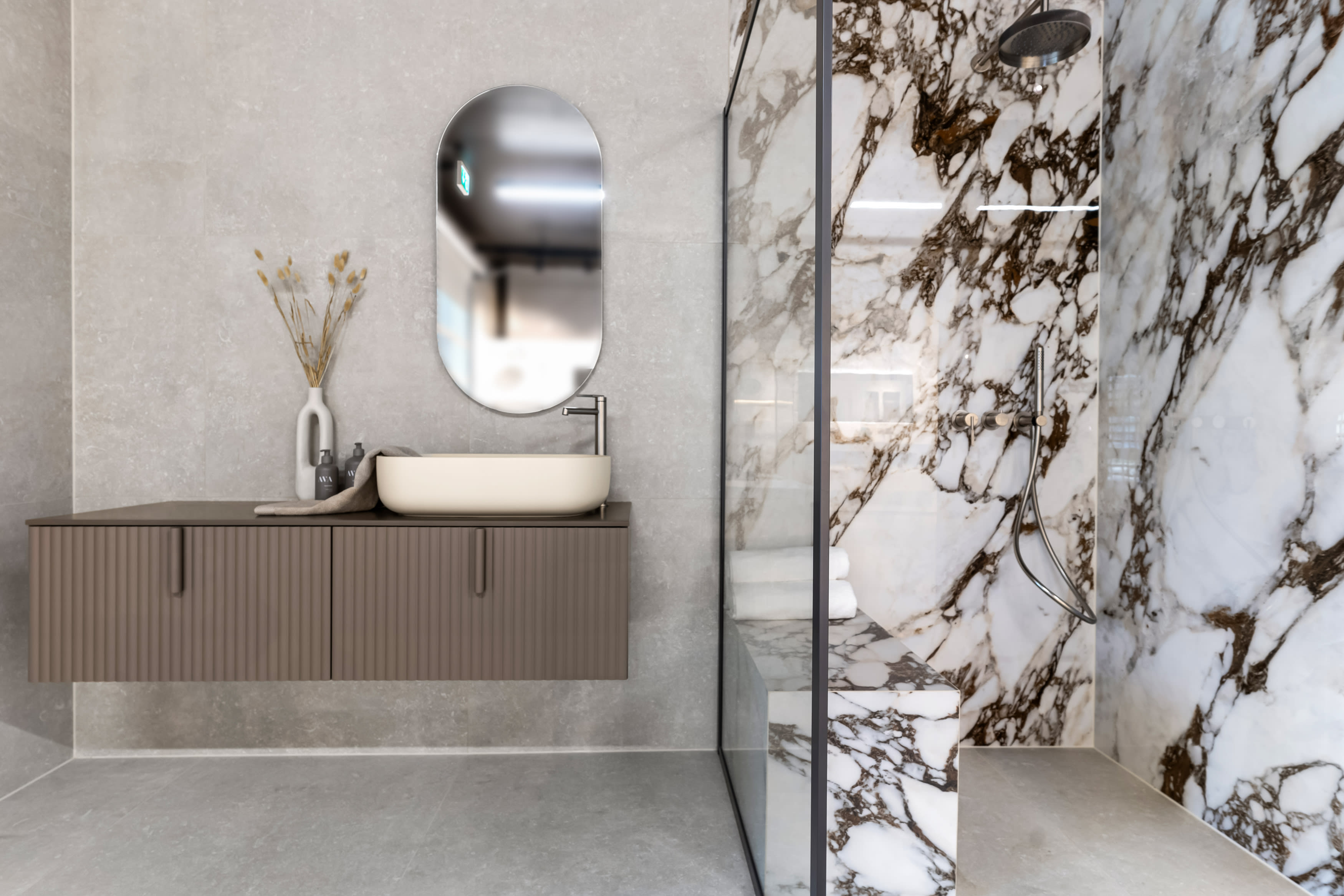 Marmorfliser som storformatfliser på baderom med skreddersydd baderomsinnredning. Servantbatteri og takdusj i brushed nickel farge.