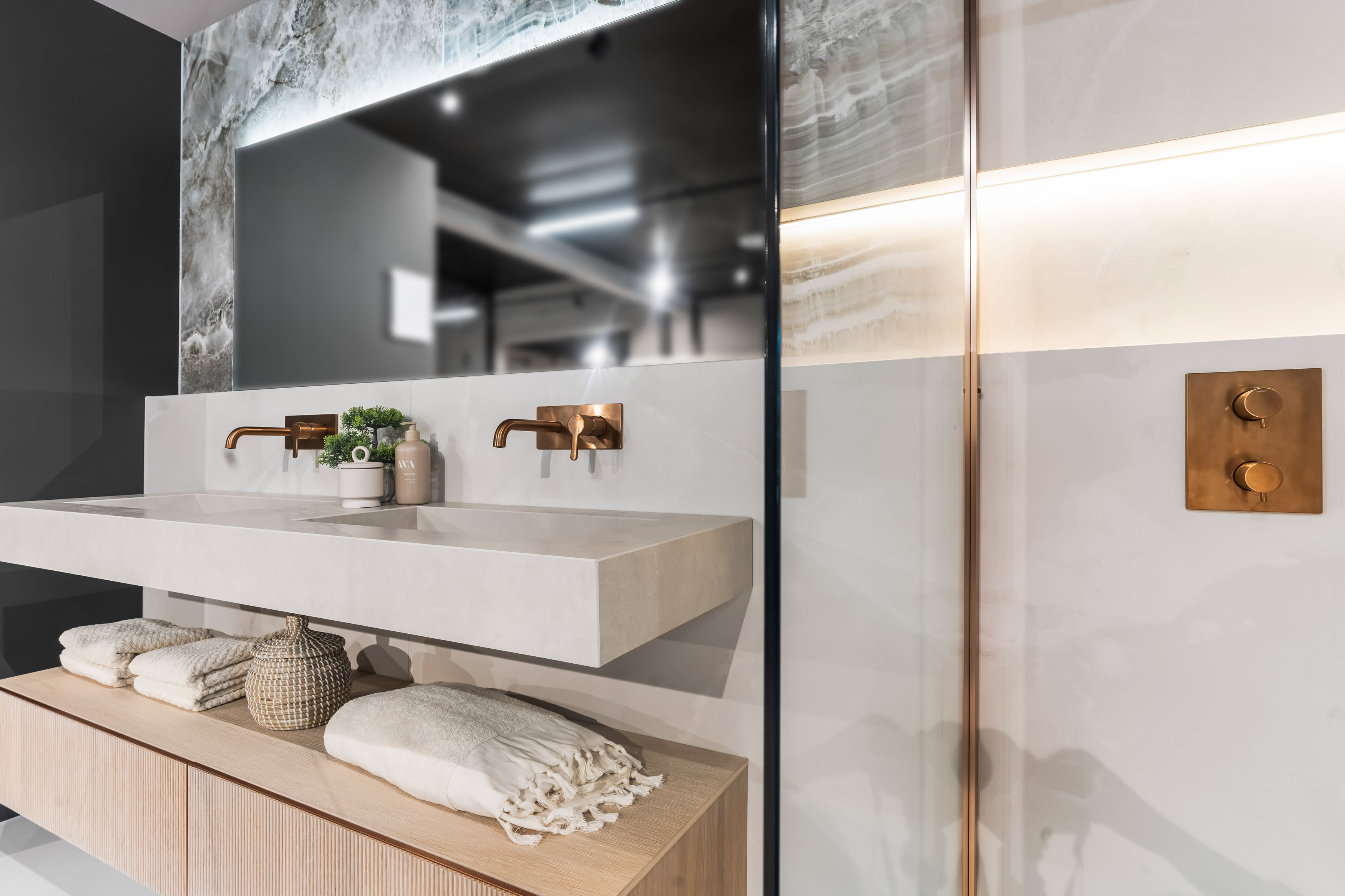 The Room fliser på baderom med innebygd servantbatteri og takdusj i kobber