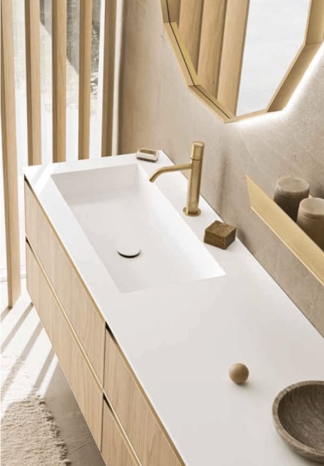 Nordisk baderom med baderomsinnredning i tre med lys benkeplate og messing blandebatteri.