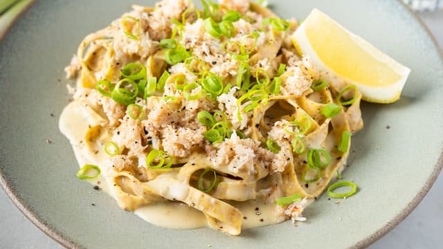 Finhakk vårløken, og vend inn krabbekjøttet og vårløken i pastaen før servering.