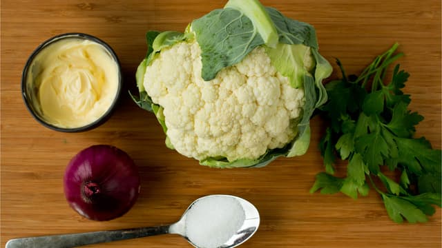 Del blomkålen i minibuketter og skjær rødløken i tynne strimler. Visp sammen majones, sukker og eddik.