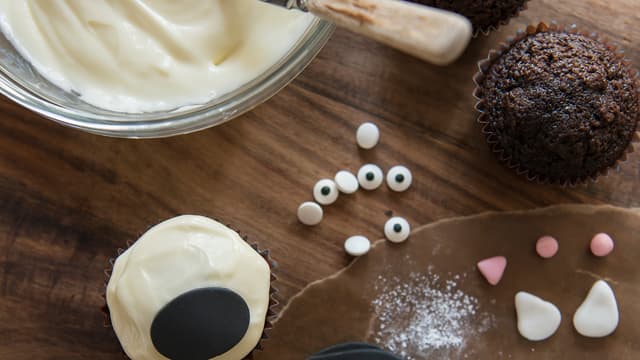 Pynte katt: Smør kremostfrosting på sjokolademuffinsen.