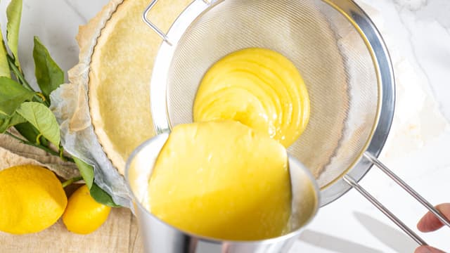 Hell fyllet over tertebunnen, gjennom en sikt så du unngår klumper. Sørg for å få så mye som mulig gjennom. Smør raskt utover med en slikkepott så du får en jevn overflate.