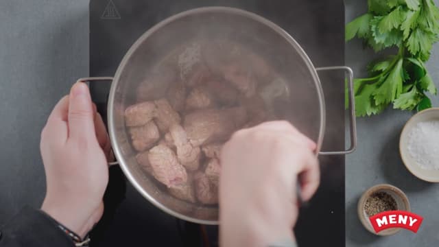 Brun reinsdyrkjøttet og løken i olje.