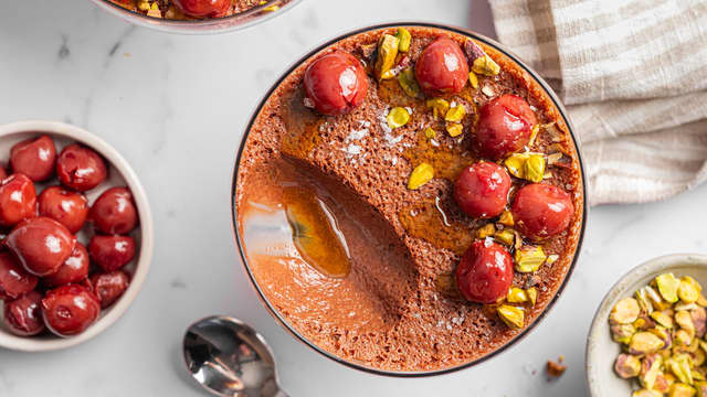 Ha sjokolademoussen over i 4 glass og sett i kjøleskapet til den stivner. Pynt desserten med hakkede nøtter, kirsebær og gjerne litt ekstra olivenolje.