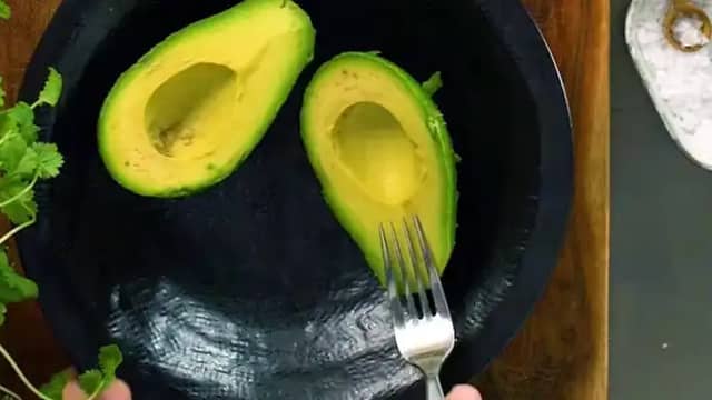 Knus avokadokjøttet med en gaffel og vend inn limesaft. Smak til med salt og pepper.