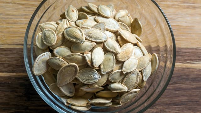 **Skyll gresskarkjernene i kaldt vann** og la dem renne av. Tørk med tørkepapir og ha over i en skål.