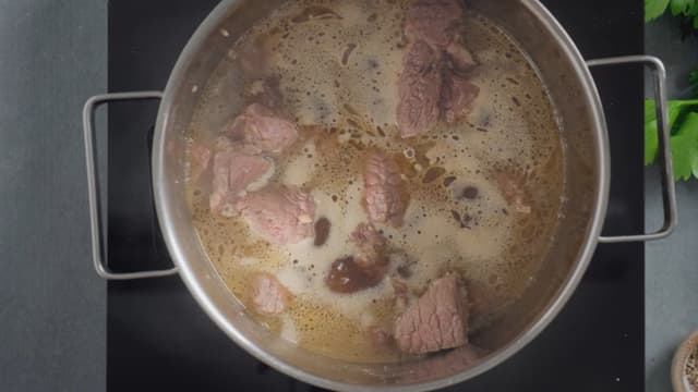 Ha kjøttet over i en gryte når det er ferdig brunet. Tilsett kraft og kok opp. La det putre til kjøttet begynner å bli mørt, ca. én time.