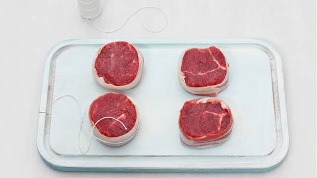 Snurr bacon rundt biffene og fest med en grillpinne eller hyssing (alternativt ferdiglagde baconbiffer fra MENY). Kok aspargesbønner knapt møre i lettsaltet vann, ca. 3-4 min. Avkjøl i kaldt vann og la renne godt av.