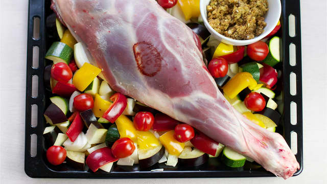 Ha olivenolje i en langpanne. Stikk et steketermometer i den tykkeste delen av kjøttet og legg lammelåret i panne. Ha grønnsakene og hele cherrytomater i pannen.