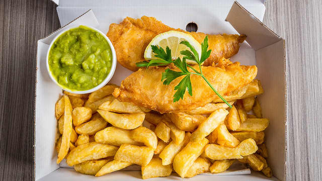 Server med pommes frites, tartarsaus og ertestuing på siden.