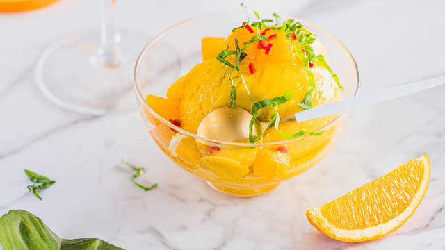 Server sorbeten i glass eller skåler sammen med appelsinbiter, basilikum og litt hakket chili.