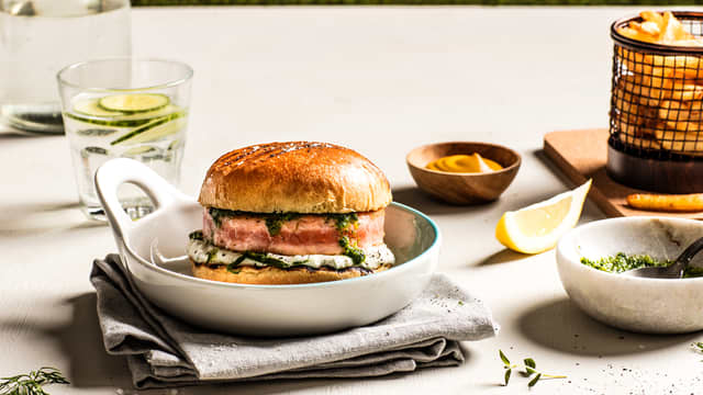 Legg en skje tzatziki på nederste del av hvert hamburgerbrød. Legg så på grillet salmaburger og chimichurri.