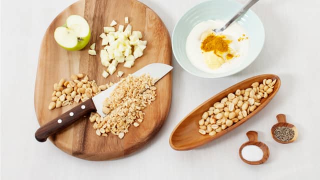 Hakk peanøtter, skjær eplet i små terninger og rør sammen peanøttsausen. Smak til med salt og pepper.
