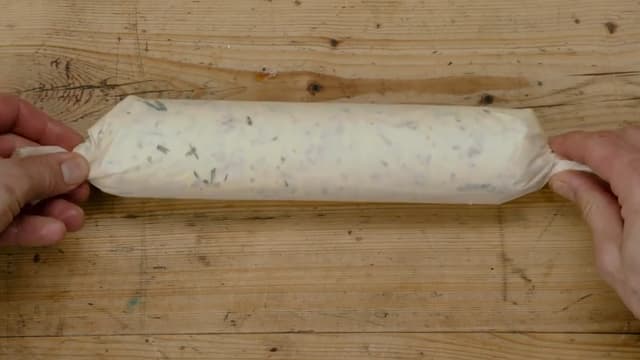 Snurr endene rundt for å lukke igjen og legg pølsen med urtesmøret i kjøleskapet.