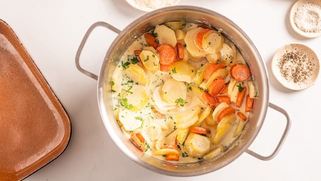 Bland inn grønnsakene og la det hele småputre i 10–15 minutter. Rør forsiktig av og til, så det ikke fester seg i bunnen.