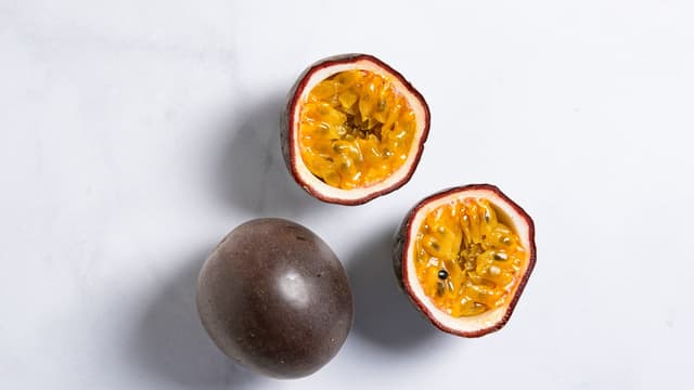 Del pasjonsfruktene i to og skrap ut fruktkjøttet. Ha pasjonsfrukt, appelsinsaft og sukker i en kasserolle. Kok opp, og la sausen småkoke til sukkeret er oppløst.