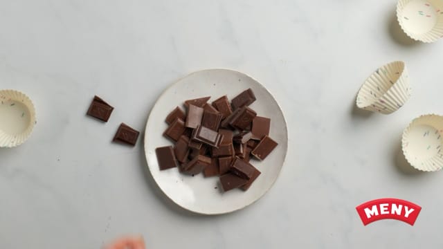 Forvarm ovnen til 170 grader på varmluftsfunksjon, og kle to bakebrett med bakepapir. Hakk sjokoladen i biter.