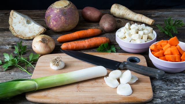 Mens kjøttet koker, skreller du grønnsakene og potetene, og kutter dem i terninger.