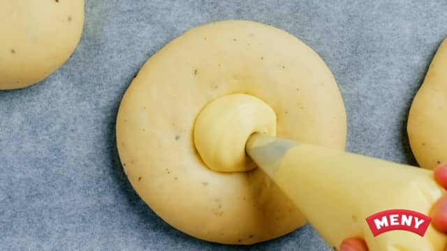 Legg ca. 1 ss med vaniljekrem på hver bolle. Pensle så med egg rundt kanten av bollene.