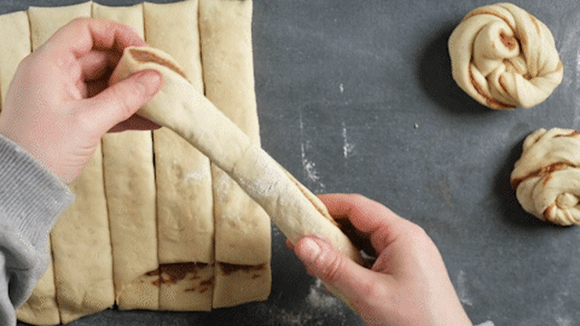 Hold en strimmel i endene, strekk den litt ut og surr deigen et par ganger rundt to fingre, før du lager en knute.