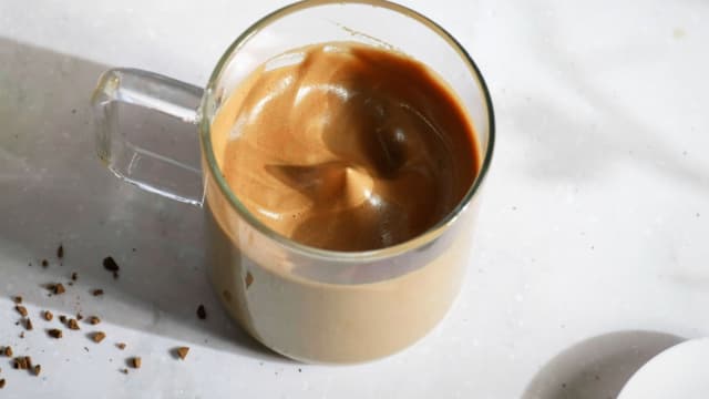 Kok opp vann. Ha instant coffee (pulverkaffe), sukker og varmt vann i en bolle. Pisk til luftig skum med en visp.