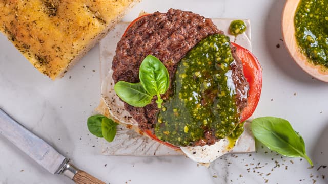 Anrett focacciabunnene på to tallerkener og legg på tomater, mozzarella, pesto og hamburgere. Legg på toppen av focacciaene.