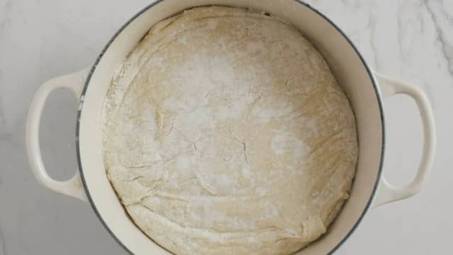 Ta gryten ut av ovnen, dryss mel i bunnen og vend deigen raskt over i gryta. Bruk gjerne en deigskrape for å få den over i en hel klump. Dryss toppen med mel, legg på lokk og stek i gryten i ovnen i 30 minutter.