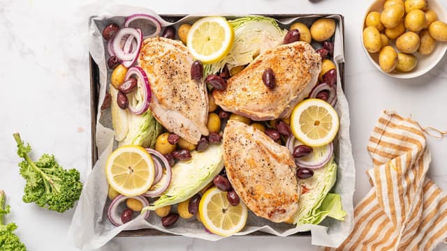 Legg perlepoteter, sitronskiver, kål, løk og oliven i en ildfast form. Vend inn olivenolje og krydre med salt og pepper. Legg kyllingbrystene oppå grønnsakene.