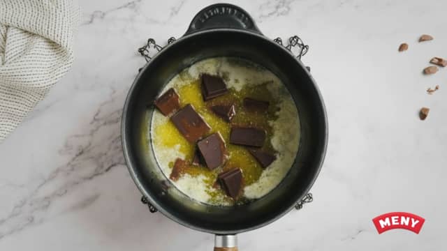 Dra kjelen av varmen og ha i sjokoladen. La blandingen stå i 3 minutter før du rører til sjokoladen og smøret er godt blandet.