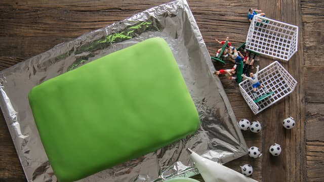 Bland melis og vann til du får ønsket tykkelse på glasuren. Tegn opp strekene på banen med melisglasur og sprøytepose.