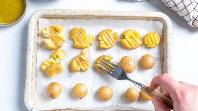 Bruk en gaffel eller undersiden av et glass og knus potetene.