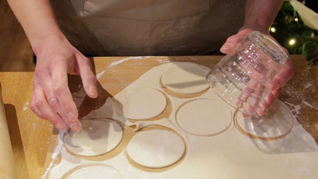 Del deigen i tre. Pakk inn 2/3 i plast og legg kjølig. Resten kjevles ut til den er ca. 2 mm tynn. Stikk ut sirkler med utstikkerringer, kjøkkenglass eller lignende.