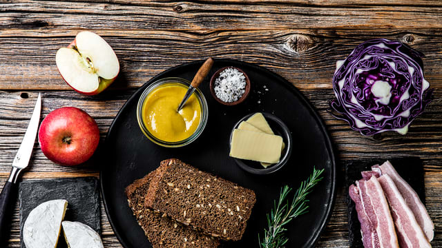 Smør skivene med sennep og legg noen osteskiver på hver.