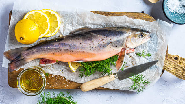 Del sitronen i skiver og legg sitronskiver og dill inni fisken.