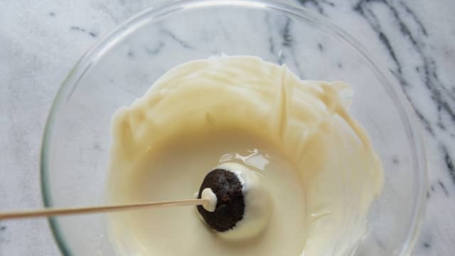 Dypp så kulen i hvit eller mørk sjokolade smeltet på vannbad.