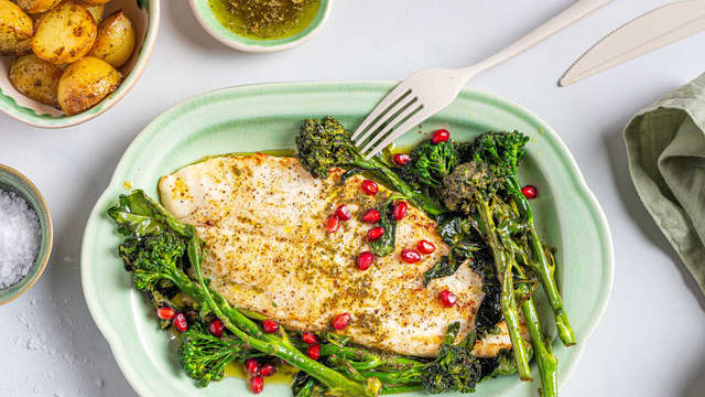 Anrett piggvaren på et fat sammen med poteter og brokkolini. Ha over ramsløksmøret og granateple før servering.