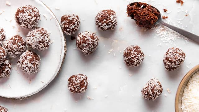 Smelt sjokoladen over vannbad. Dypp bollene i sjokoladen. Dypp eller rull i ekstra kokos utenpå bollene om du ønsker det.