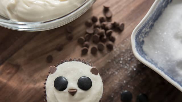 Pynte panda: Smør kremostfrosting på cupcaken, dypp så cupcaken i sukker.