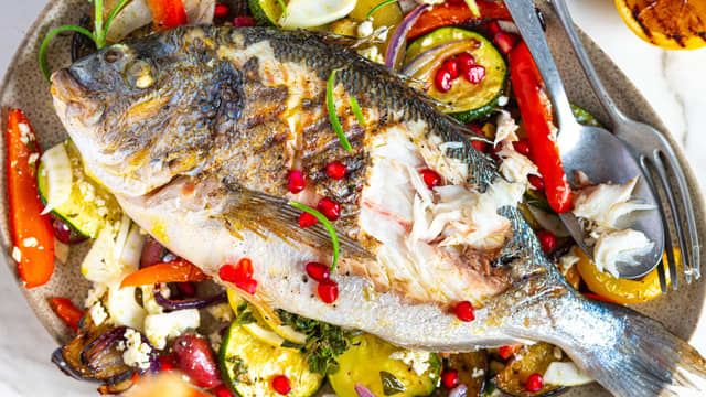 Server den grillede doraden med de bakte middelhavsgrønnsakene.