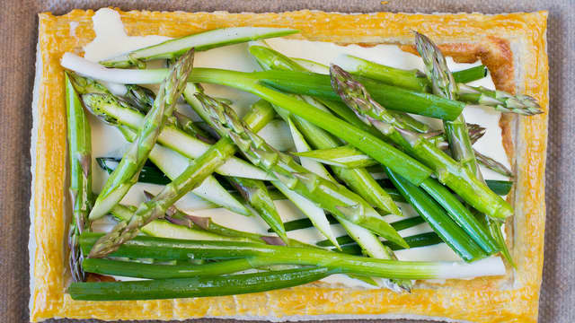 Stek bunnen ved 200 grader i ca. 10 minutter, eller til fyllet har blitt gyllent og kanten har hevet seg og fått litt farge. Hell forsiktig over resten av fyllet og legg på vårløk og asparges. Stek terten videre i ovn i ca. 20 minutter.