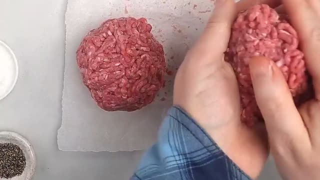 **Hjemmelaget burger:** Ha litt vann på en fjøl og form fire burgere. Ikke jobb for mye med kjøttdeigen. Krydre burgerne med salt og pepper.