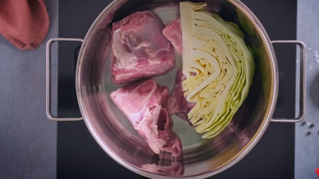 Legg kjøtt og kål lagvis i en stor kjele. Begynn med et lag kjøtt med fettsiden ned. Strø salt og hel pepper mellom lagene.